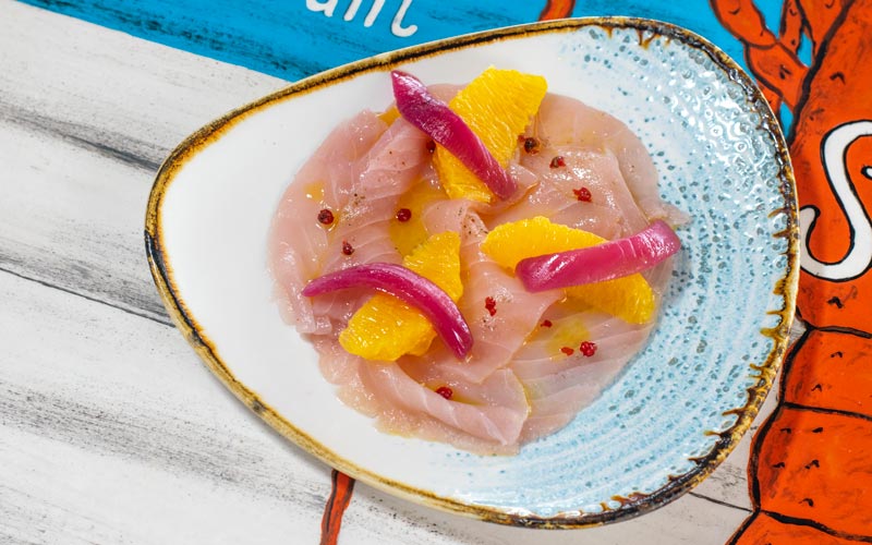 PalmBeach Tropical Restaurant | Amberjack Carpaccio Marinated in Orange and Pink Pepper | puff pastries with fish marinated in an emulsion of lemon juice, orange and oil, served with pink pepper and grilled bread croutons