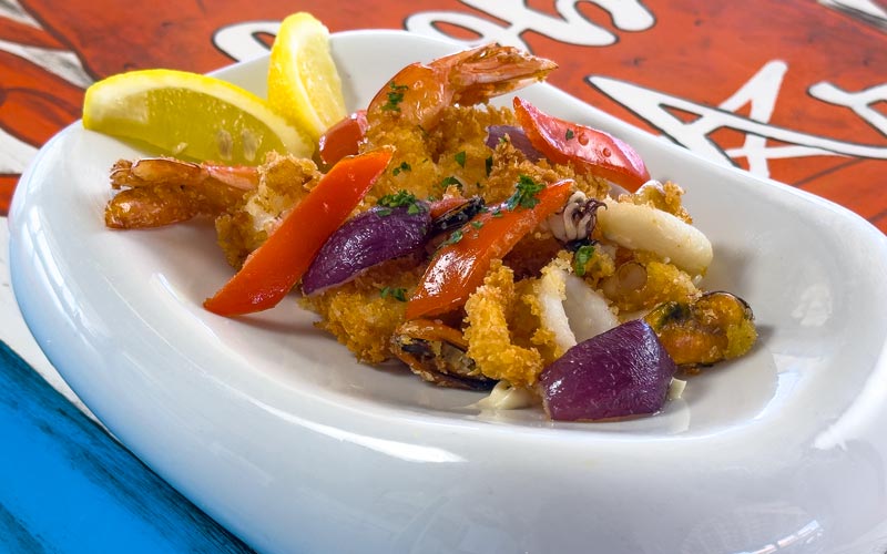 PalmBeach Tropical Restaurant | Signature Panko-Crusted Seafood Fry | shrimp, squid, amberjack, mussels, bell peppers, and red onion